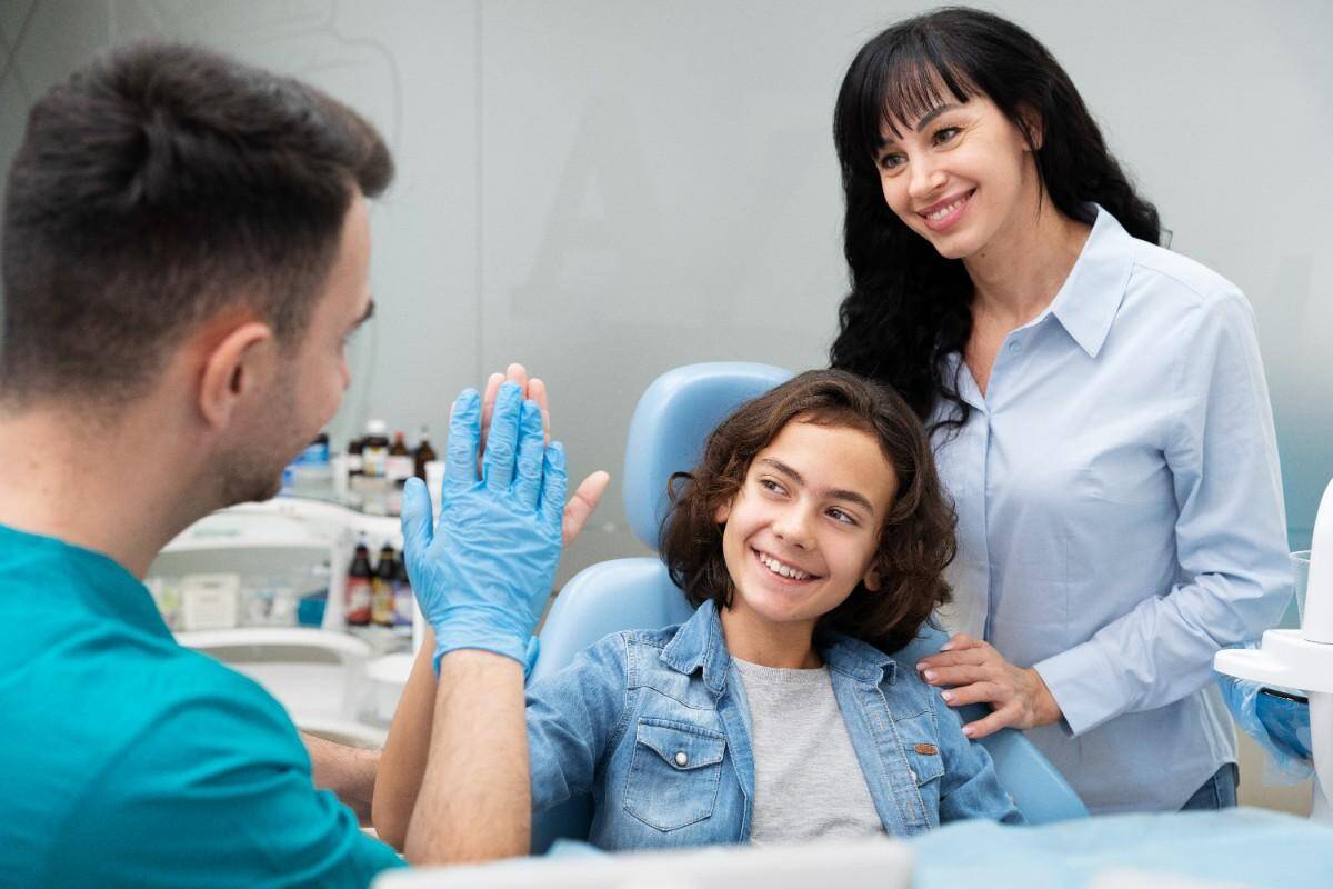 Child high-fiving dentist during checkup